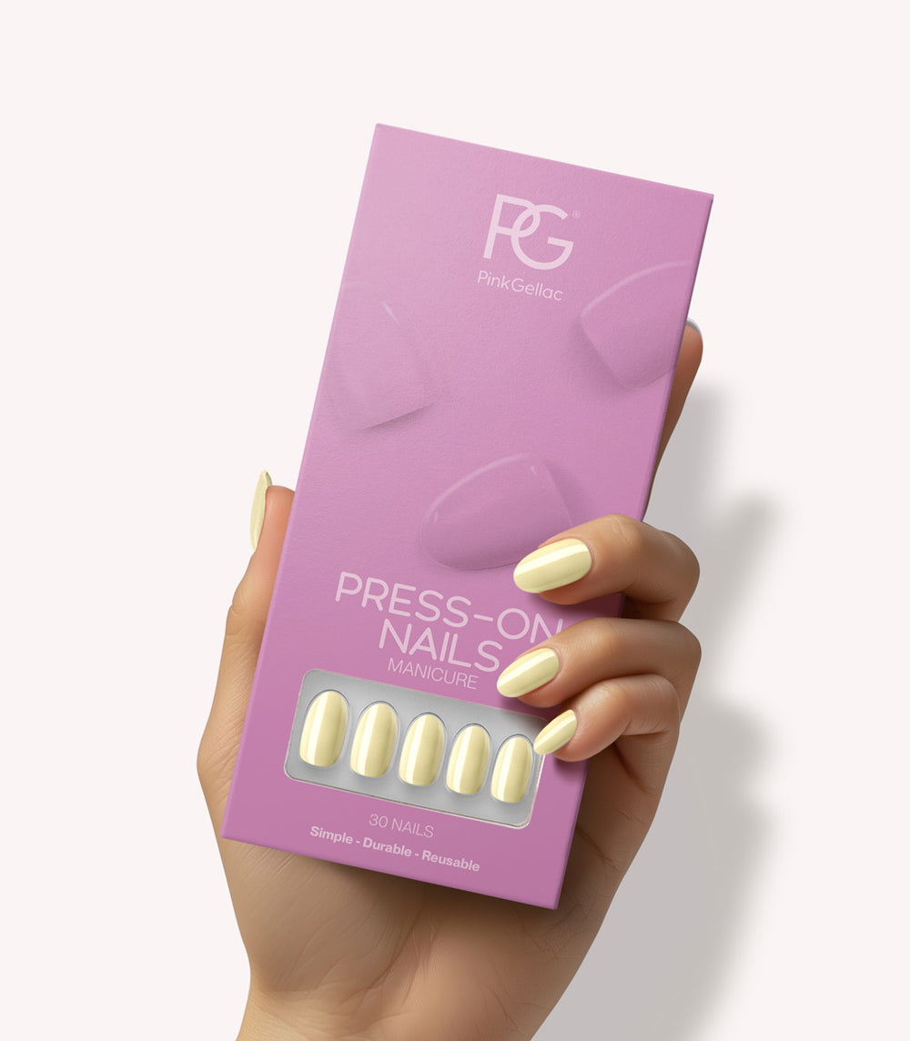 Hand holding Pink Gellac 487 Yummy Yellow press-on nails in their packaging.