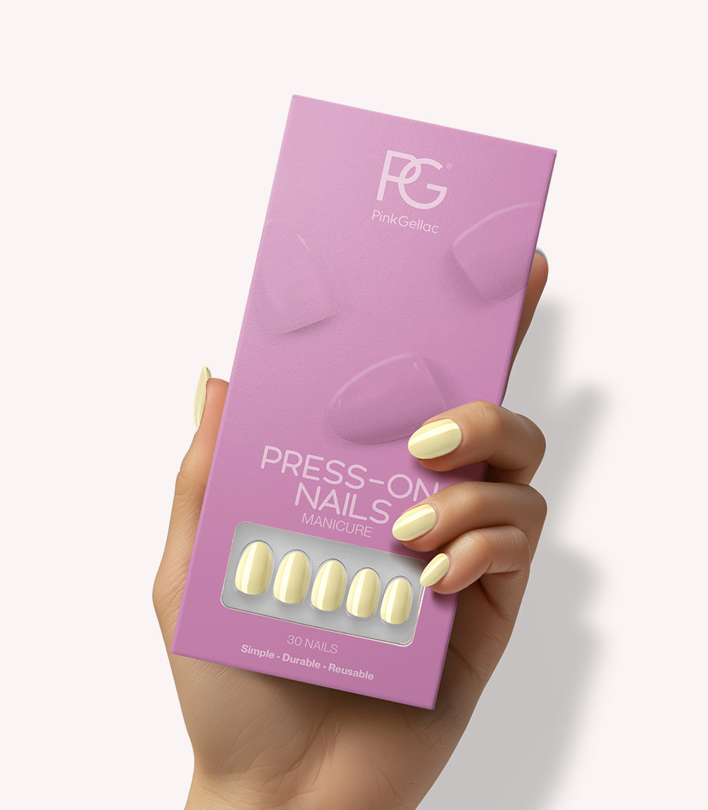 Hand holding Pink Gellac 487 Yummy Yellow press-on nails in their packaging.