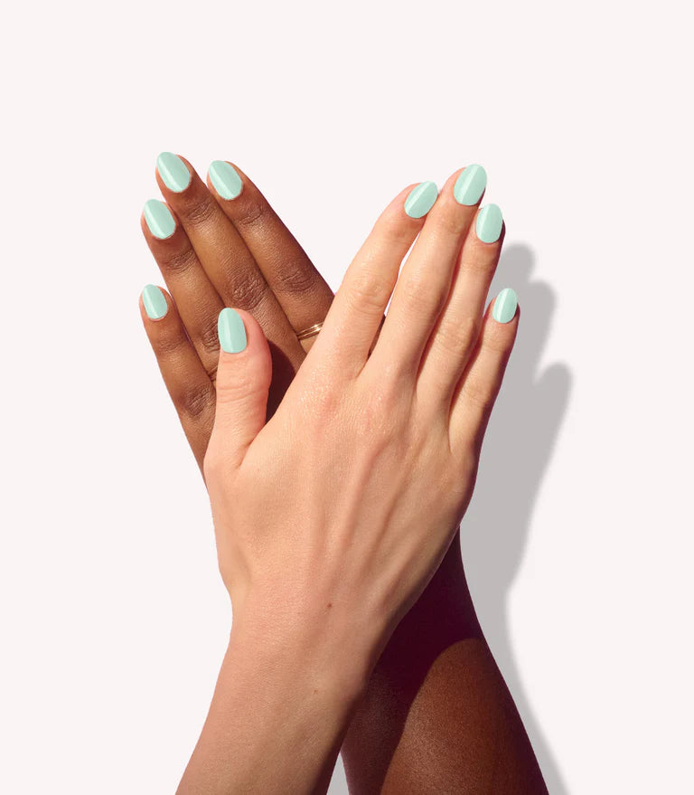 Close-up of a woman with Pink Gellac Melted Mint manicured nails near her face.
