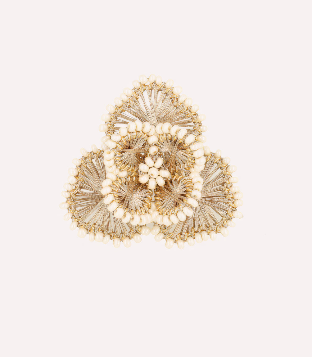 Decorative golden rose ornament on a light background.