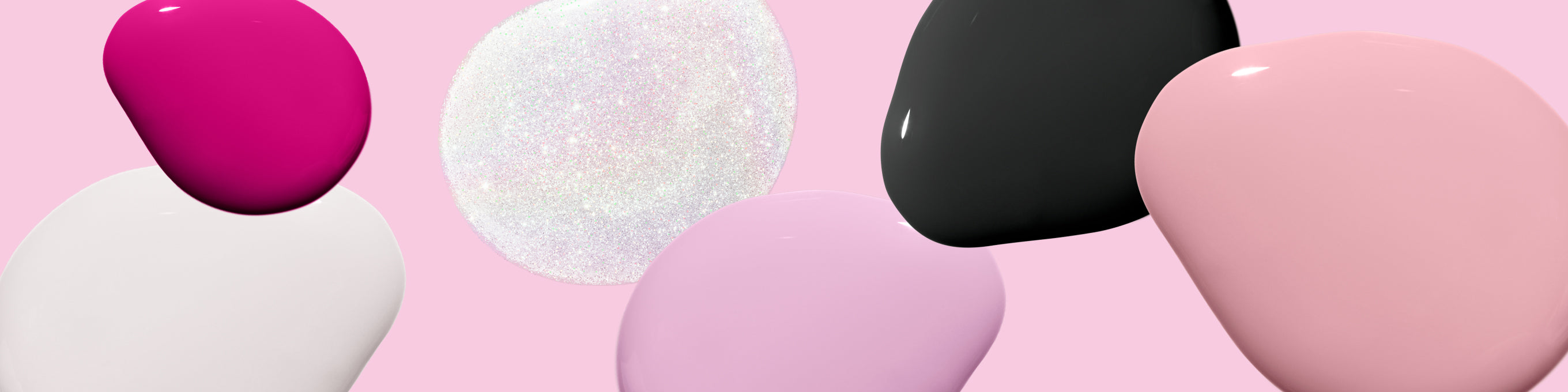 Several drops of nail polish in pink, white, black and shimmering, on a pastel pink background.