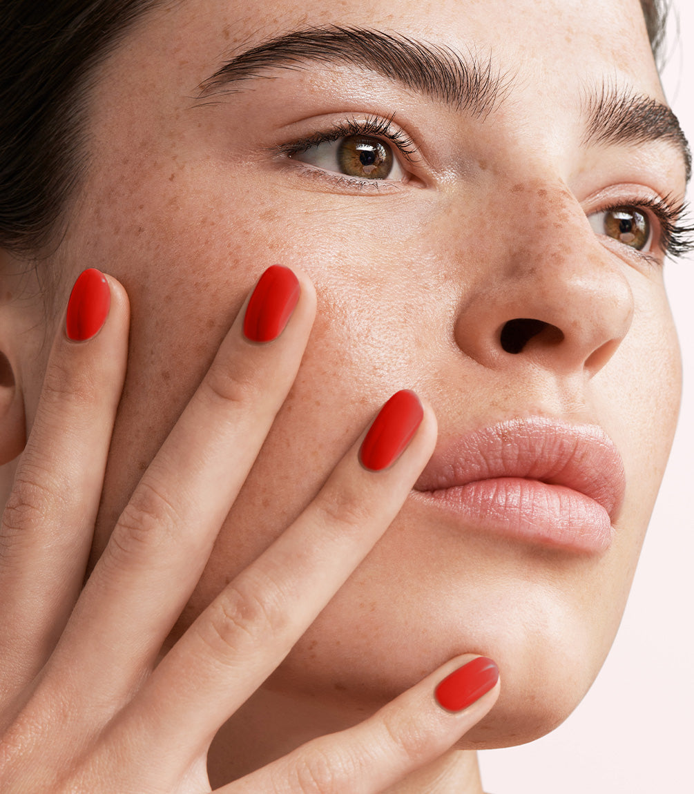 Close-up of a woman with Pink Gellac 108 Lady in Red manicured nails near her face.