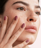 Close-up of a woman with Pink Gellac 110 Mystic manicured nails near her face.