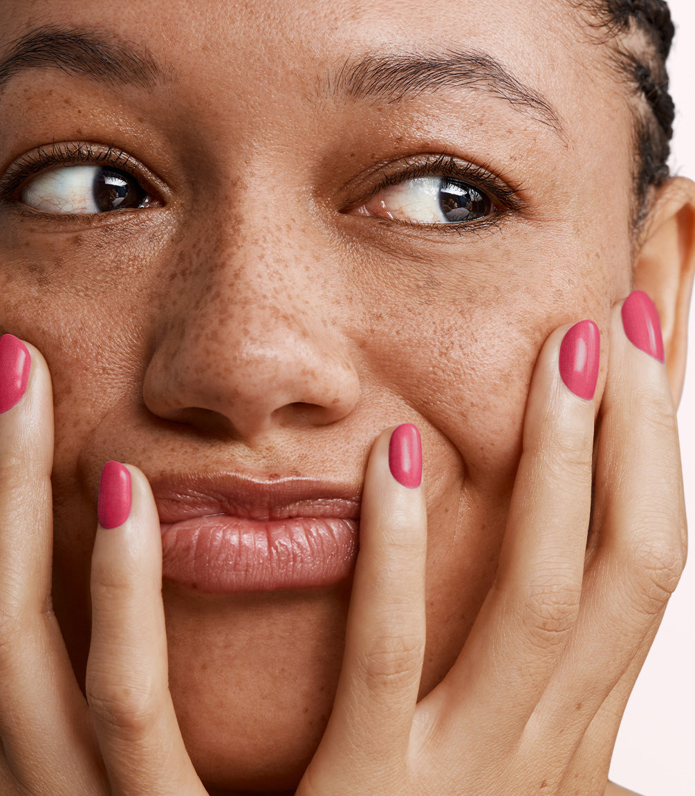 Close-up of a woman with Pink Gellac 182 Dynamic Pink manicured nails near her face.