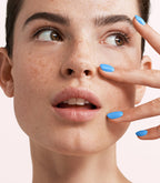 Close-up of a woman with Pink Gellac 269 Surfing Blue manicured nails near her face.
