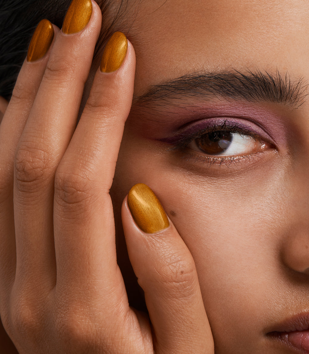 Close-up of a woman with Pink Gellac 417 Beloved Bronze manicured nails near her face.