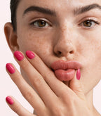 Close-up of a woman with Pink Gellac 437 Magenta Muse manicured nails near her face.