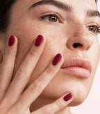 Close-up of a woman with Pink Gellac 439 Berry Sheen manicured nails near her face.