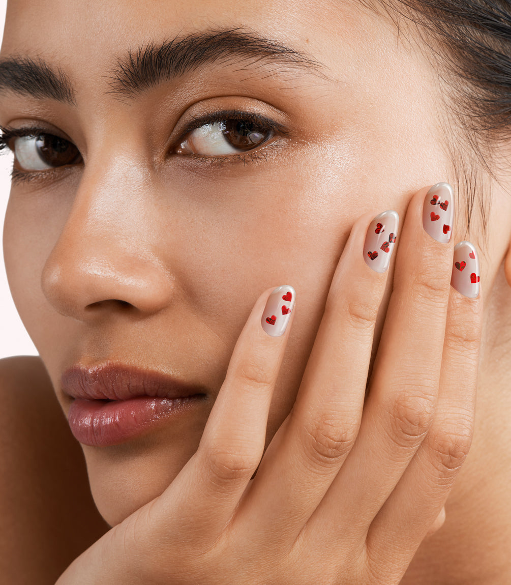 Close-up of a woman with Pink Gellac 440 Cupid's Glitter manicured nails near her face.