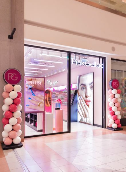 Shop façade of Pink Gellac with colorful balloon decoration on either side of the entrance and a modern interior visible through the windows.