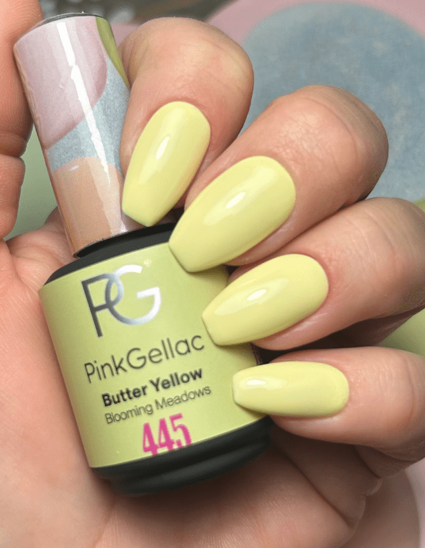 Yellow gel nails polished with Pink Gellac in the shade "Butter Yellow" (number 445), held in a hand with a bottle of the nail polish.
