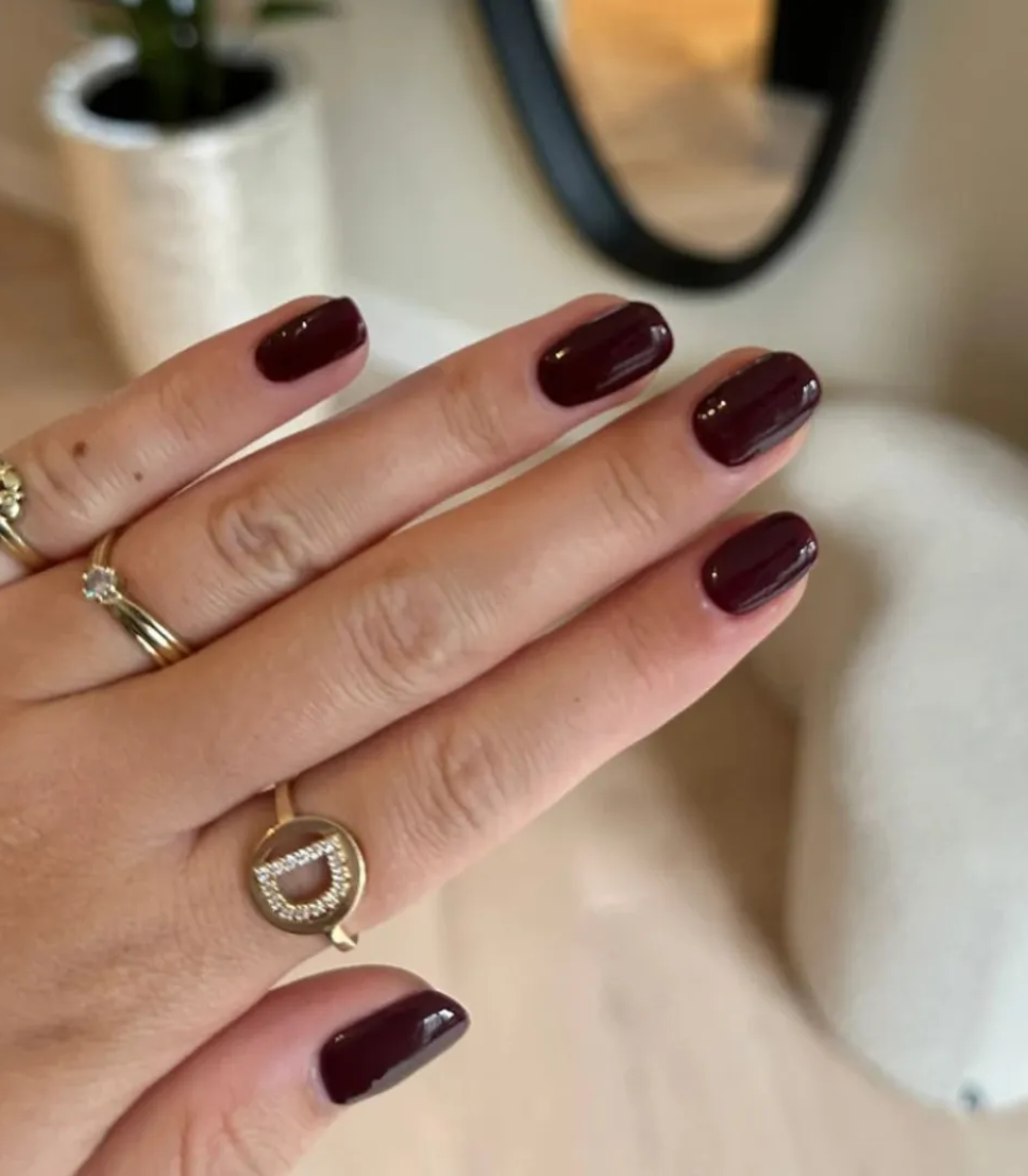 Hand with manicured nails wearing Pink Gellac 112 Chique Red gel polish.