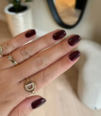 Hand with manicured nails wearing Pink Gellac 112 Chique Red gel polish.