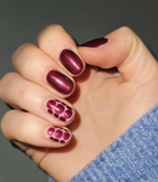 Hand with manicured nails wearing Pink Gellac 205 Burgundy Red gel polish.