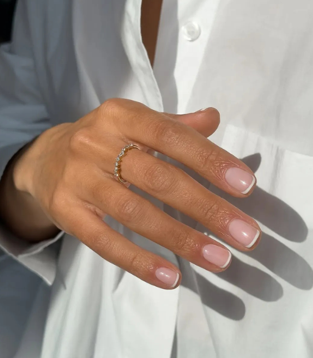 Hand with manicured nails wearing Pink Gellac 299 Coco White gel polish.