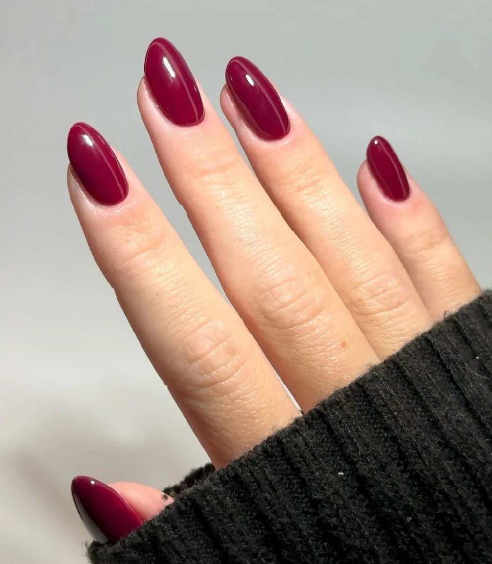 Hand with manicured nails wearing Pink Gellac 307 Maroon Purple gel polish.