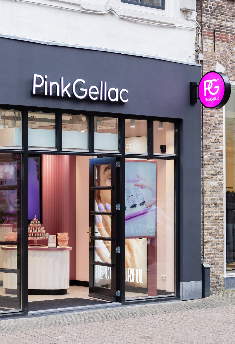 Facade of the store "Pink Gellac" with open door, pink interior and product displays visible.