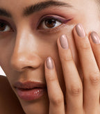 Close-up of a woman with Pink Gellac 125 Bronzy Pink manicured nails near her face.