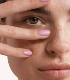 Close-up of a woman with Pink Gellac 242 Pastel Purple manicured nails near her face.