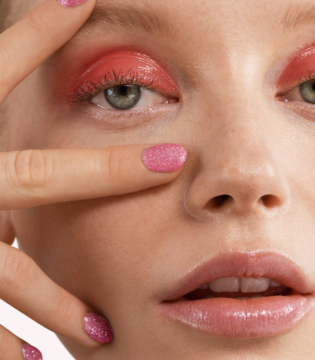 Close-up of a woman with Pink Gellac 243 Diamond Pink manicured nails near her face.