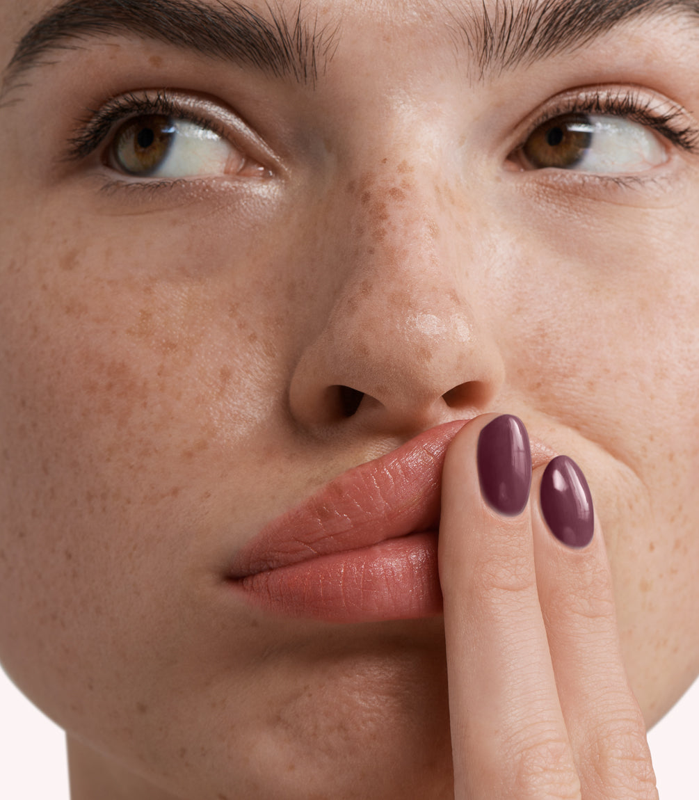Close-up of a woman with Pink Gellac 279 Muted Plum manicured nails near her face.