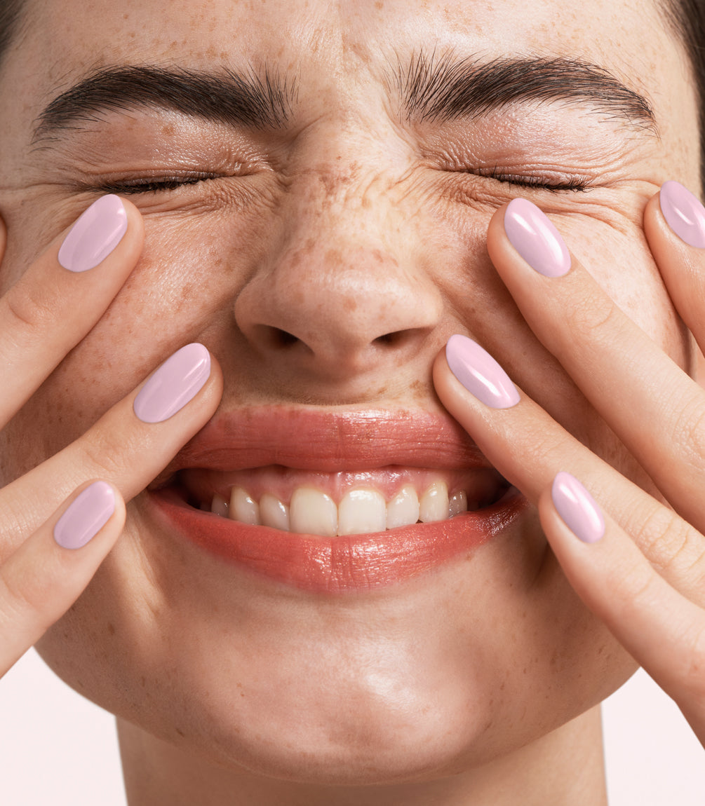 Close-up of a woman with Pink Gellac Rubber Base Cover Frosted Pink manicured nails near her face.