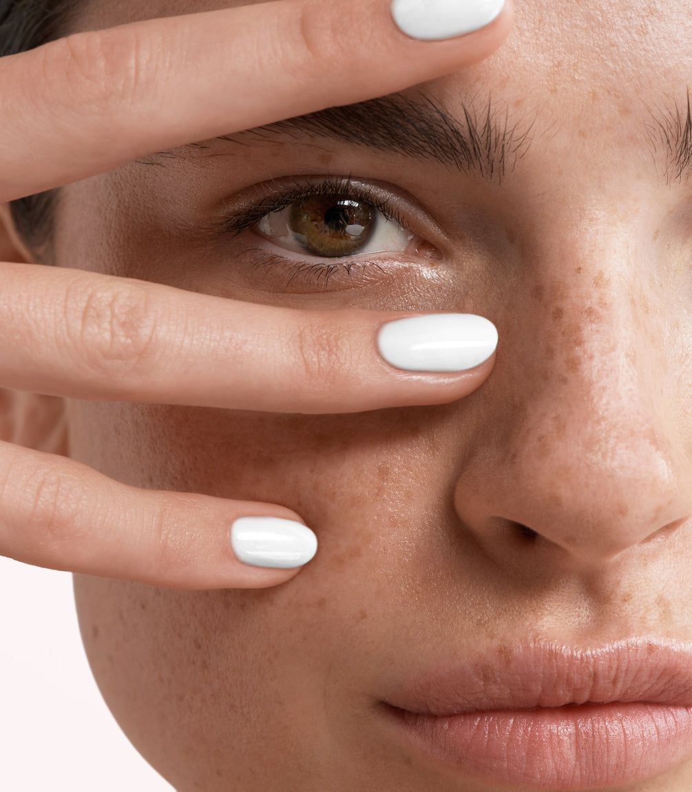 Close-up of a woman with Pink Gellac Rubber Base Cover Milky White manicured nails near her face.