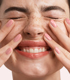Close-up of a woman with Pink Gellac Build it Base Flawless Rose manicured nails near her face.