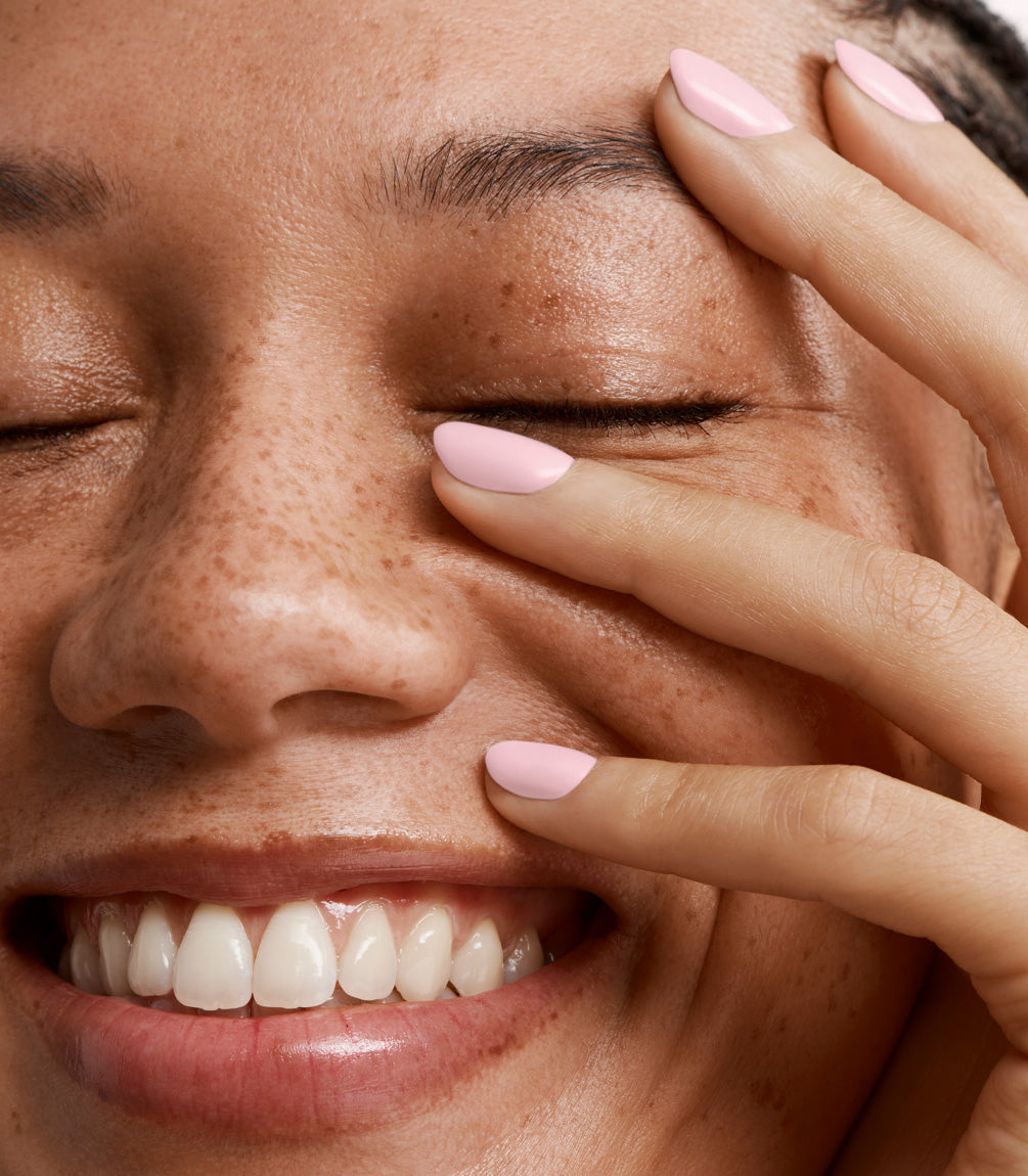 Close-up of a woman with Pink Gellac Build it Base Soft Pink manicured nails near her face.