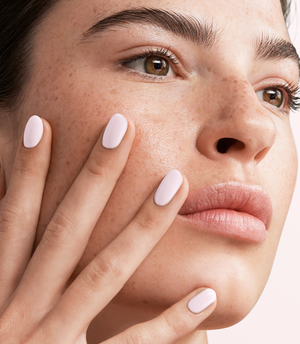 Close-up of a woman with Pink Gellac Build it Base Silky White manicured nails near her face.