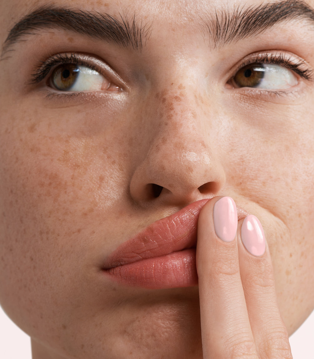 Close-up of a woman with Pink Gellac Build it Base Tender Pink manicured nails near her face.