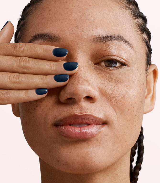 Close-up of a woman with Pink Gellac 117 Night Blue manicured nails near her face.