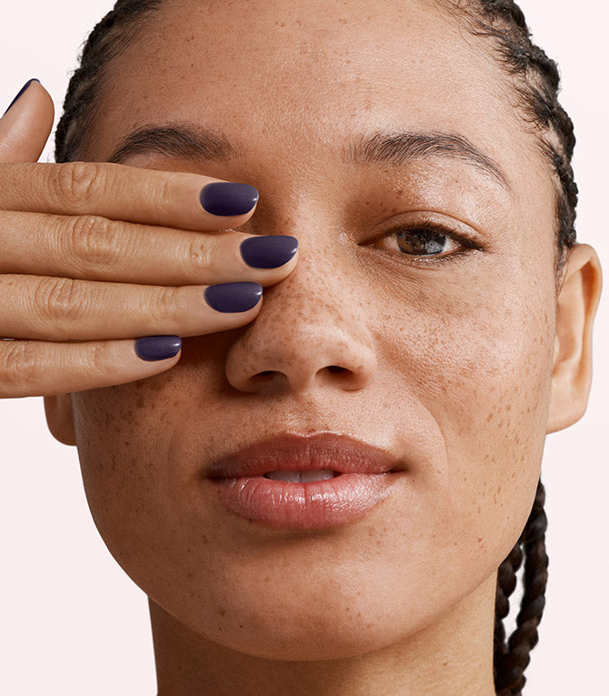 Close-up of a woman with Pink Gellac 119 Velvet Purple manicured nails near her face.