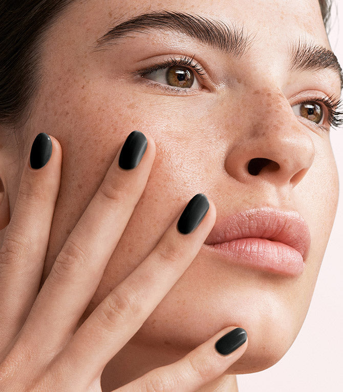 Close-up of a woman with Pink Gellac 120 Beautiful Black manicured nails near her face.