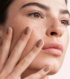 Close-up of a woman with Pink Gellac 139 Natural Taupe manicured nails near her face.