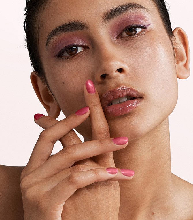 Close-up of a woman with Pink Gellac 158 Candy Pink manicured nails near her face.
