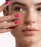 Close-up of a woman with Pink Gellac 161 Ibiza Pink manicured nails near her face.