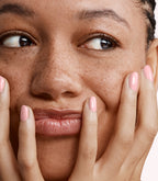 Close-up of a woman with Pink Gellac 164 Classic Pearl manicured nails near her face.