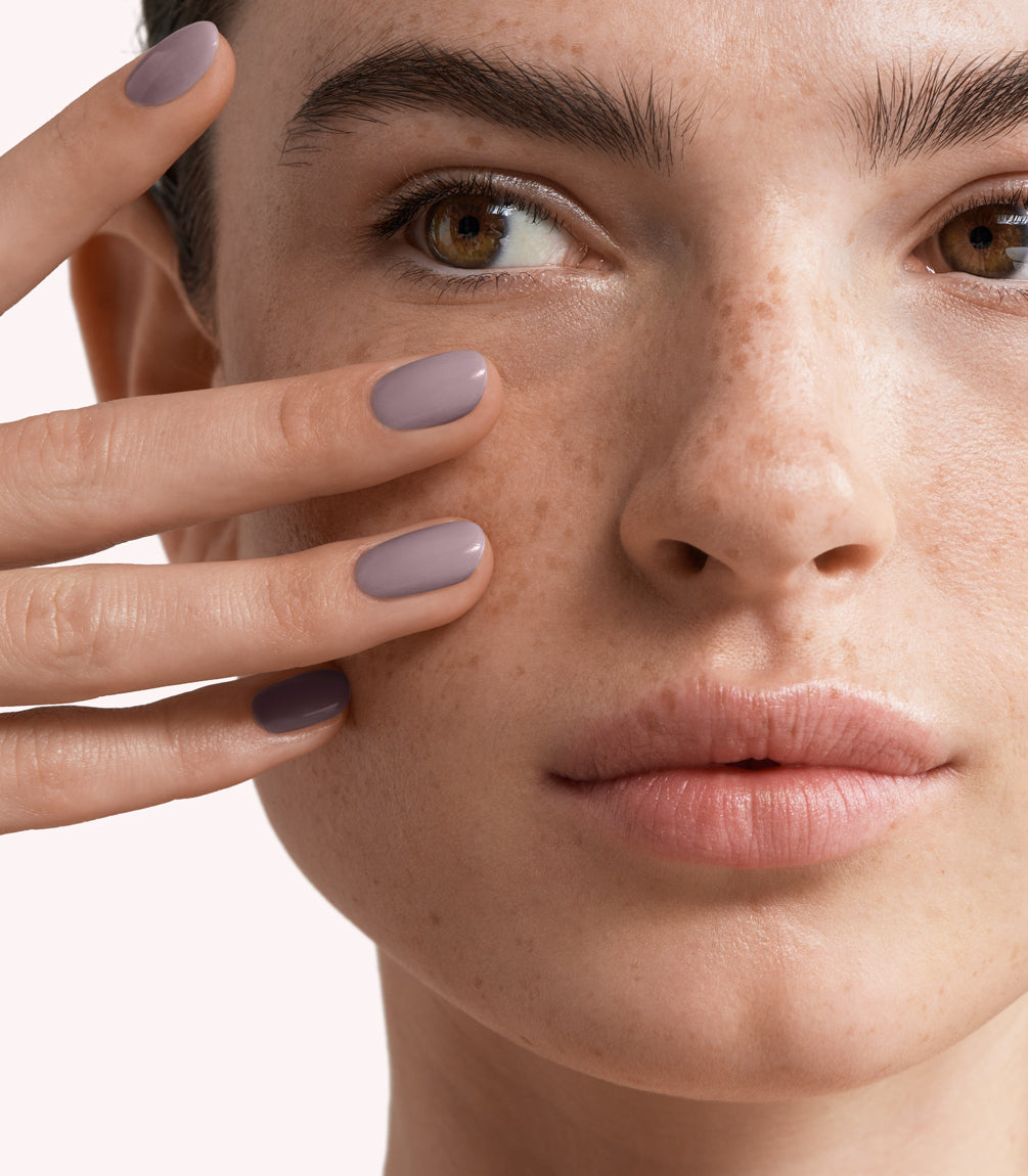 Close-up of a woman with Pink Gellac 167 Pure Cashmere manicured nails near her face.