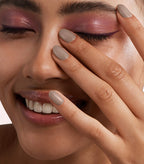 Close-up of a woman with Pink Gellac 171 Golden Rose manicured nails near her face.