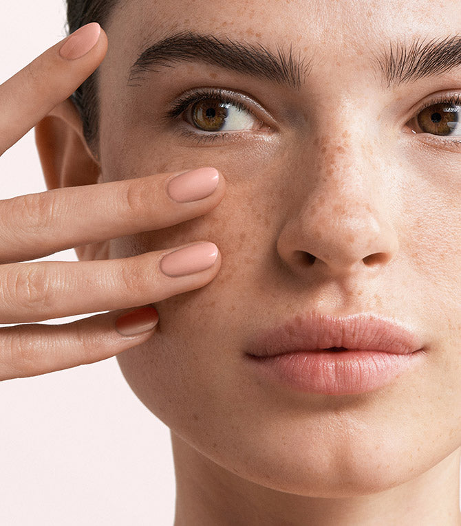 Close-up of a woman with Pink Gellac 188 Charming Nude manicured nails near her face.