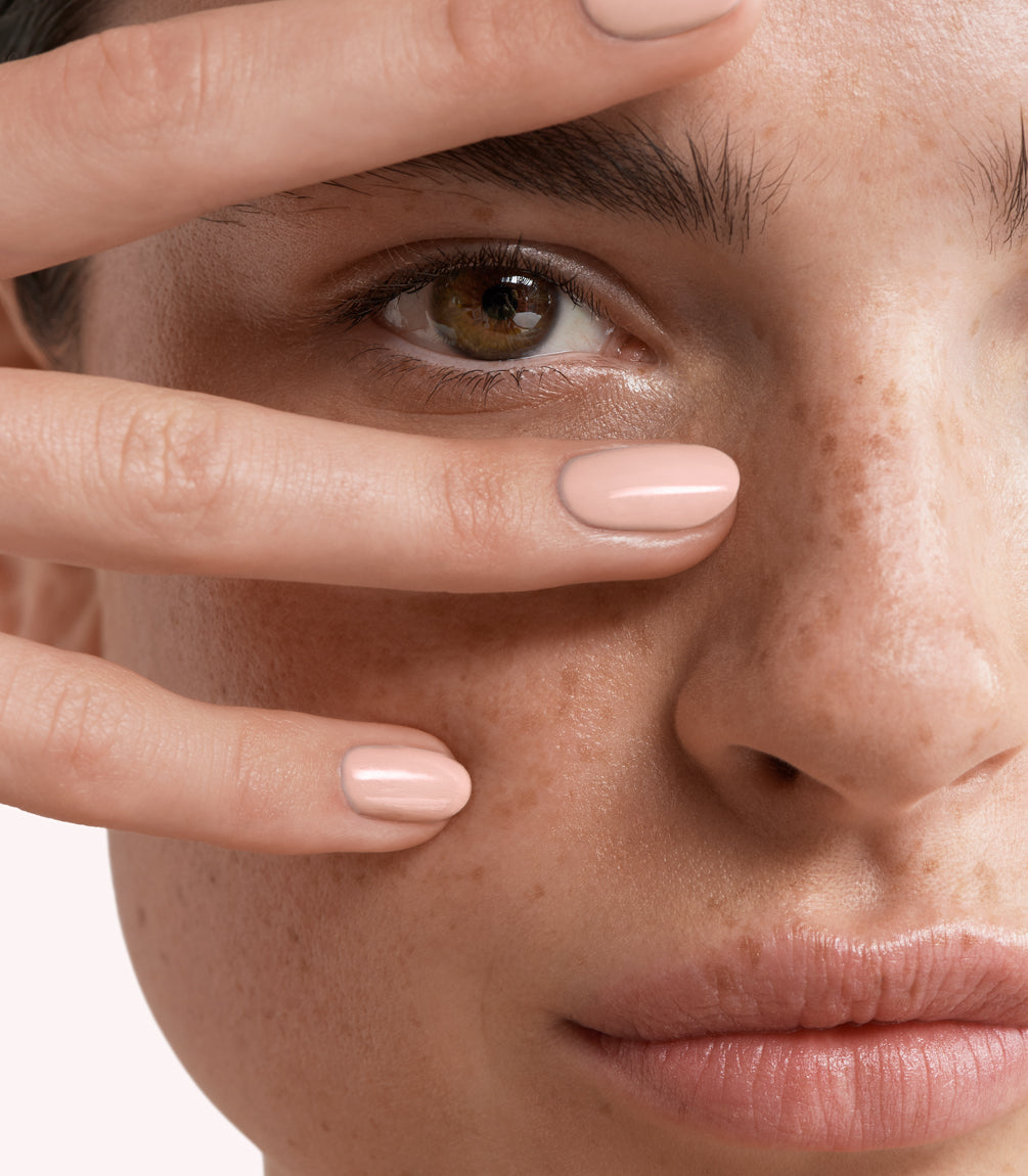 Close-up of a woman with Pink Gellac 194 Ivory Blush manicured nails near her face.