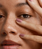 Close-up of a woman with Pink Gellac 198 Heavenly Mauve manicured nails near her face.