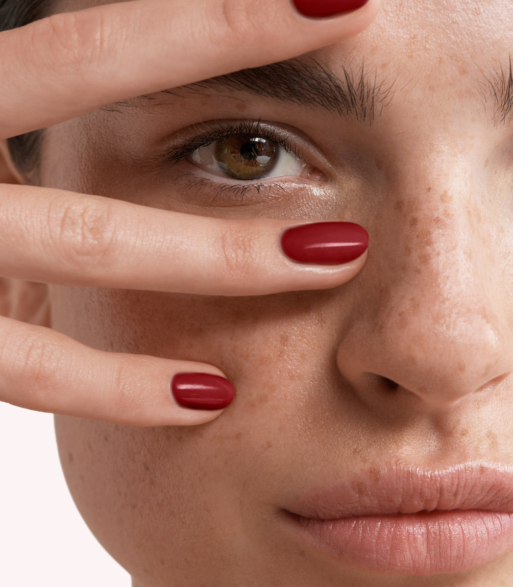 Close-up of a woman with Pink Gellac 199 Luscious Red manicured nails near her face.