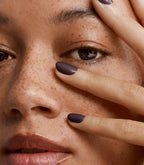 Close-up of a woman with Pink Gellac 201 Black Velvet manicured nails near her face.