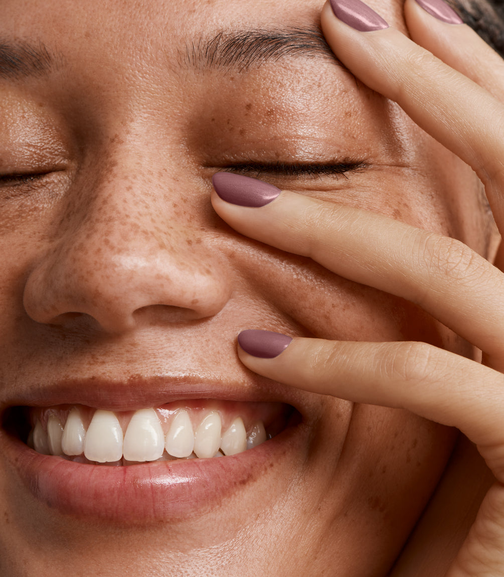 Close-up of a woman with Pink Gellac 202 Warm Marsala manicured nails near her face.