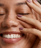 Close-up of a woman with Pink Gellac 202 Warm Marsala manicured nails near her face.
