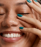 Close-up of a woman with Pink Gellac 207 Funky Teal manicured nails near her face.