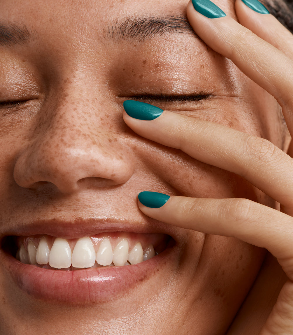 Close-up of a woman with Pink Gellac 207 Funky Teal manicured nails near her face.