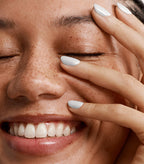 Close-up of a woman with Pink Gellac 209 Sugar White manicured nails near her face.